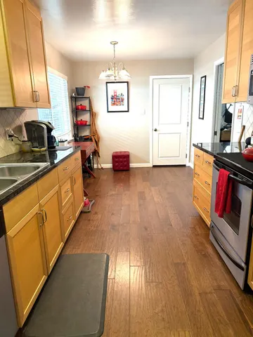 a kitchen with stainless steel appliances granite countertop a stove a sink and a refrigerator