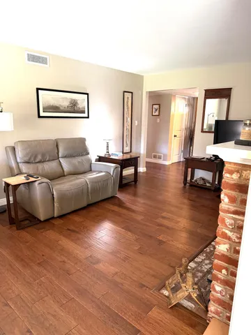a living room with furniture and wooden floor