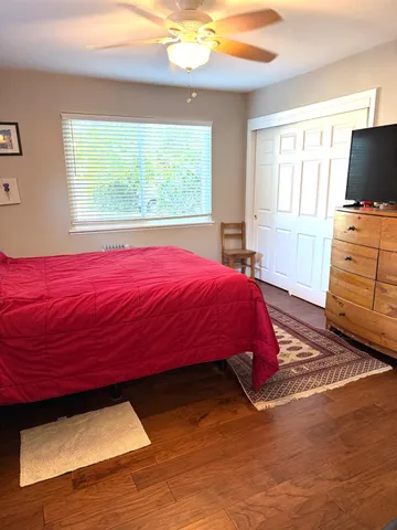 a bedroom with a bed and a flat tv screen on dresser