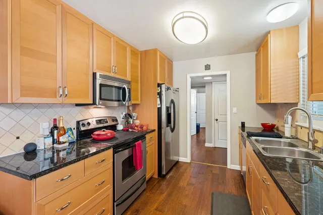 a kitchen with stainless steel appliances granite countertop a sink stove and refrigerator