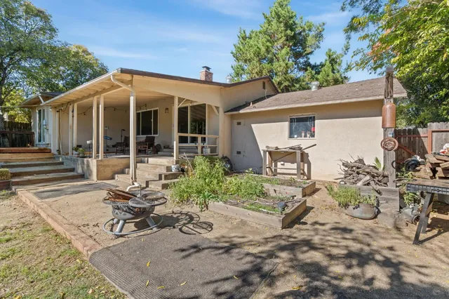 a view of a patio with table and chairs potted plants and floor to ceiling window