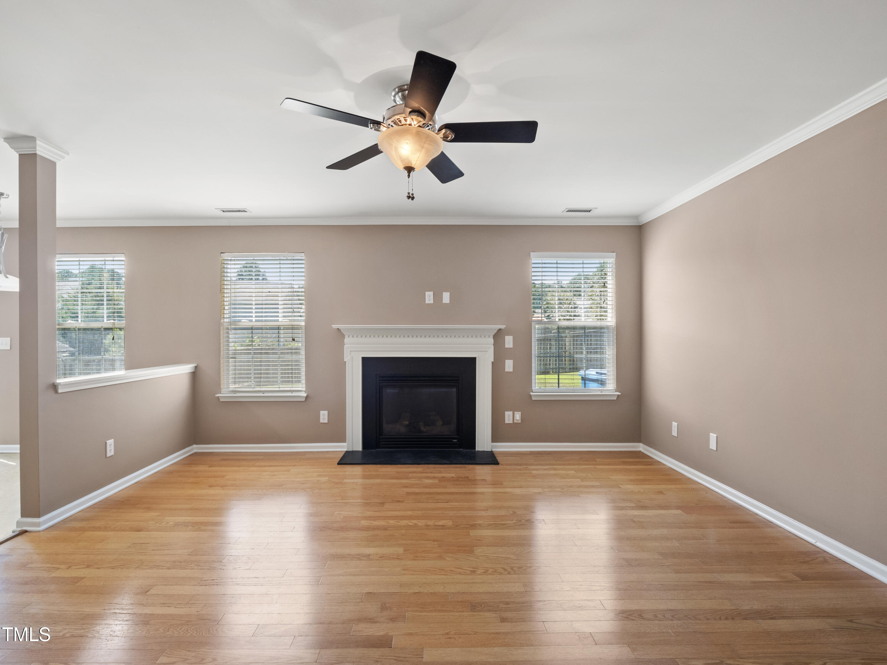 115 Geranium Street Durham, NC 27704 - Photo 15 of 47 an empty room with windows fireplace and wooden floor