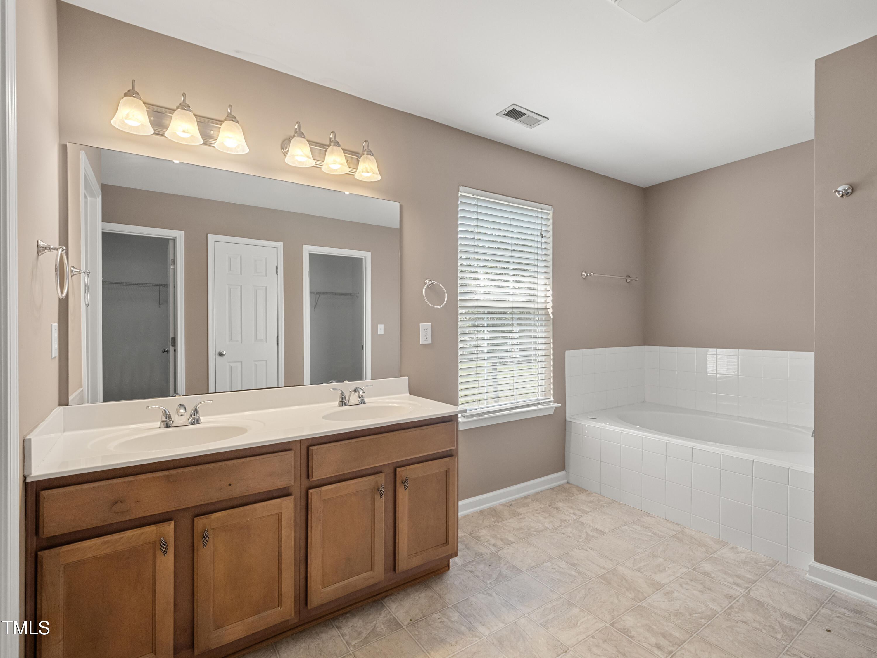 115 Geranium Street Durham, NC 27704 - Photo 47 of 47 a bathroom with a tub a sink double vanity and a mirror