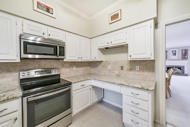 a kitchen with granite countertop cabinets stainless steel appliances and wooden floor