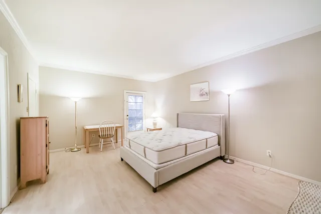 a bedroom with a bed lamp closet and large window