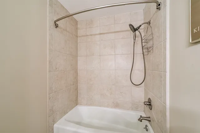 a bathroom with a bath tub with a shower