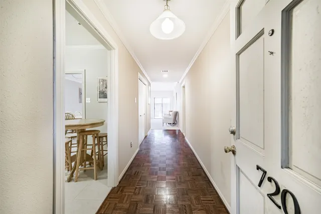 a view of a hallway with wooden floor and staircase