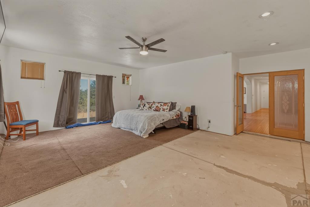 7880 Old Sopris Road Trinidad, CO 81082 - Photo 17 of 49 a spacious bedroom with a bed and a chandelier