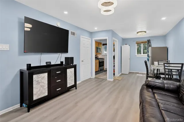 a living room with furniture and wooden floor