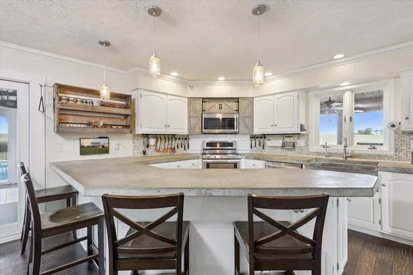 a kitchen with stainless steel appliances granite countertop a sink a stove and cabinets