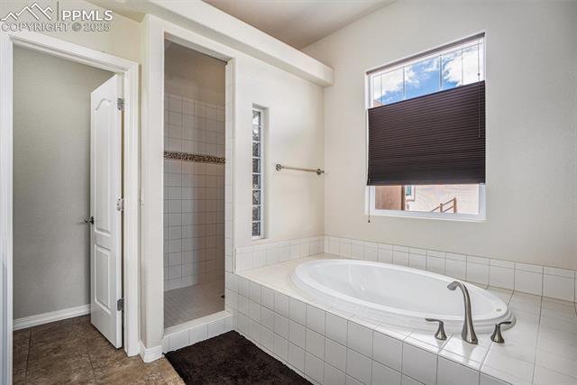9709 Rockingham Drive Peyton, CO 80831 - Photo 21 of 50 Bathroom featuring a garden tub, a stand alone tile shower, ceramic tile floor and separate commode room
