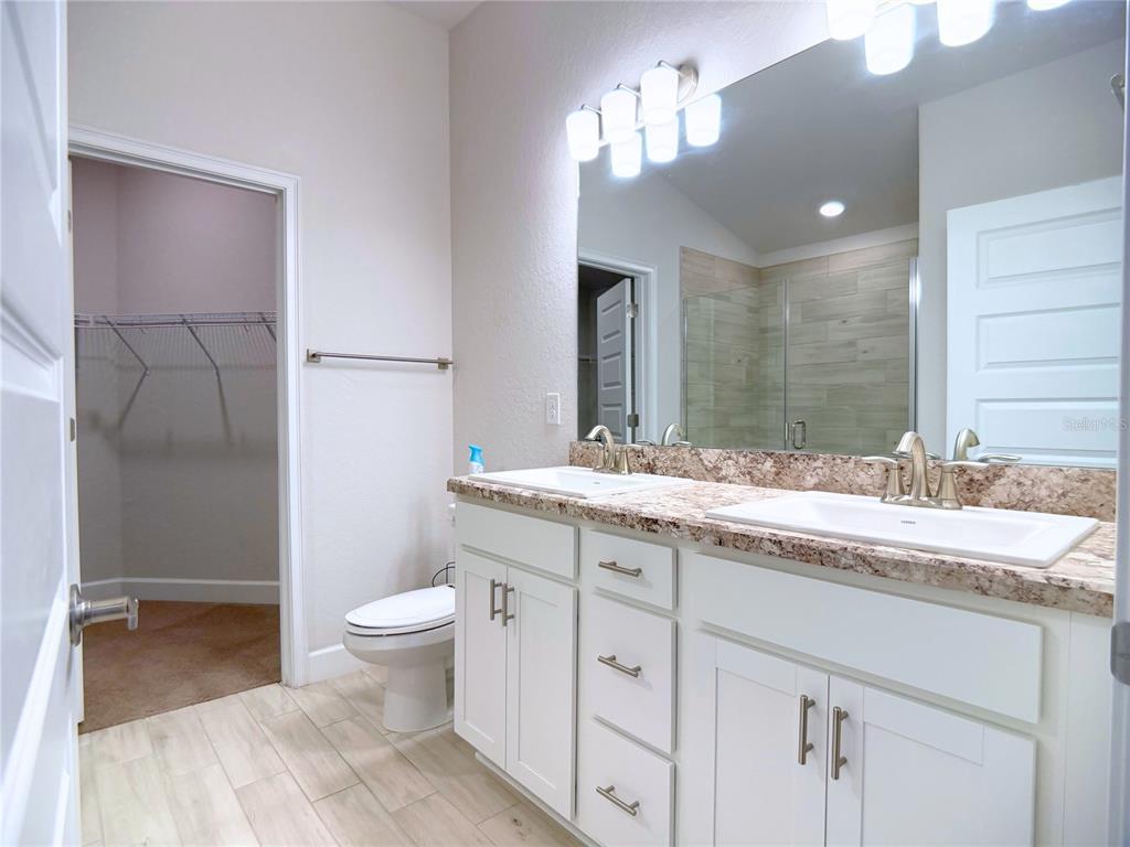 4549 Southeast 25th Loop Ocala, FL 34480 - Photo 12 of 25 a bathroom with a granite countertop sink a toilet and a mirror