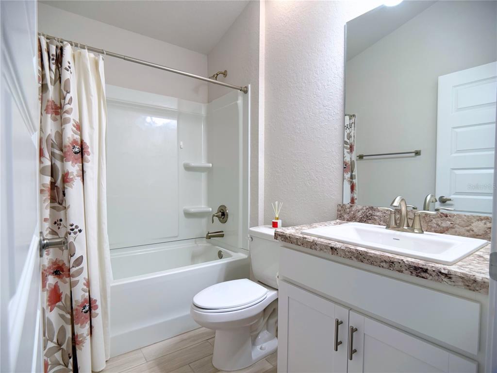4549 Southeast 25th Loop Ocala, FL 34480 - Photo 16 of 25 a bathroom with a granite countertop sink toilet mirror and bathtub