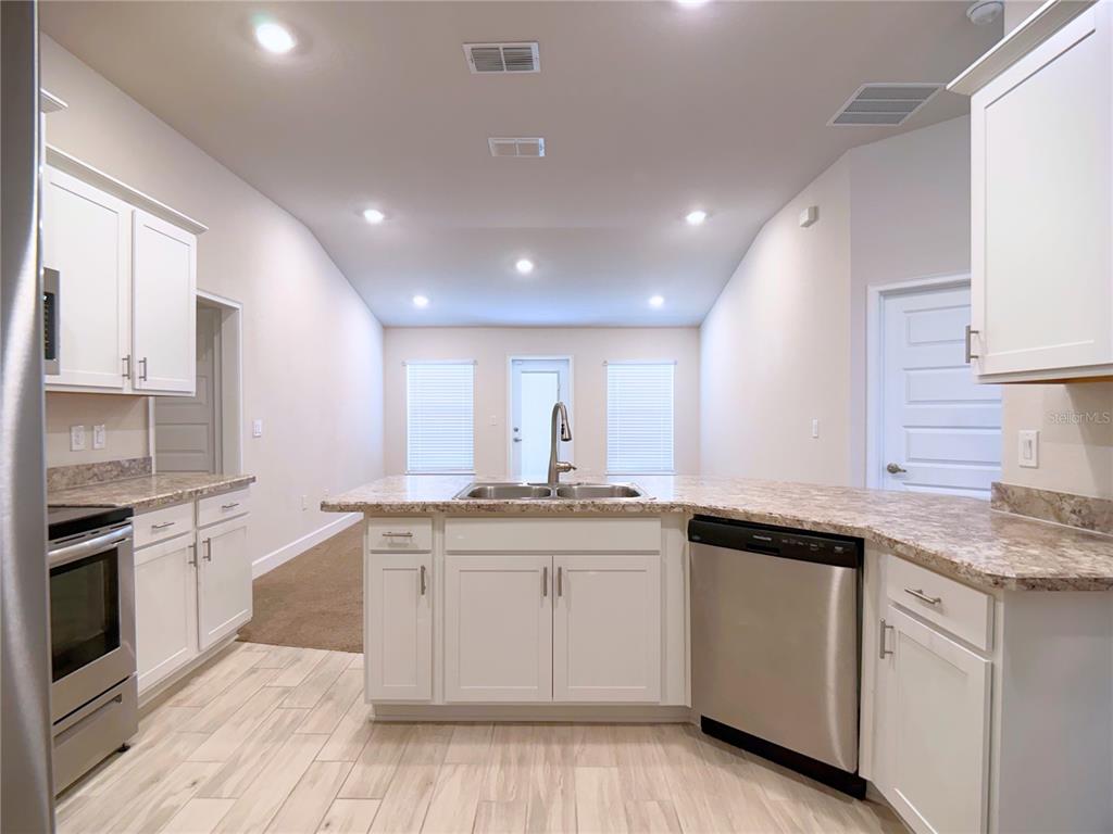 4549 Southeast 25th Loop Ocala, FL 34480 - Photo 7 of 25 a kitchen with a sink stove cabinets and wooden floor