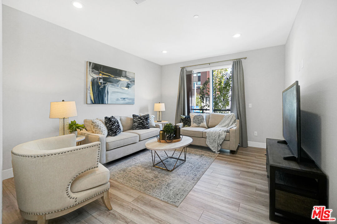 44661 Wisdom Road Fremont, CA 94538 - Photo 18 of 45 a living room with furniture a flat screen tv and a large window