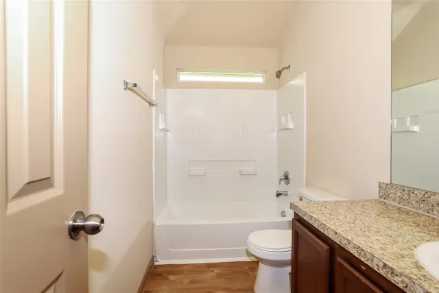 a bathroom with a granite countertop sink toilet and shower