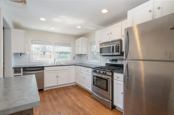 a kitchen with granite countertop a refrigerator stove and microwave