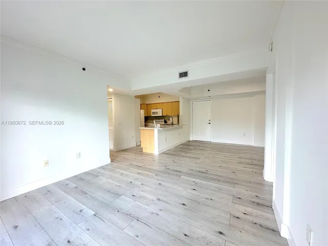 a view of empty room with wooden floor and window