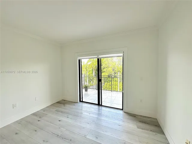 an empty room with wooden floor and sliding door