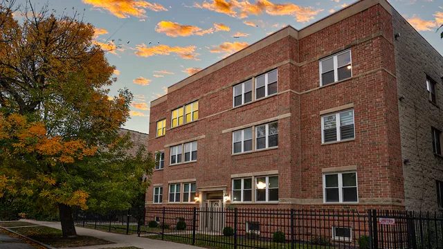a front view of a building with lot of trees
