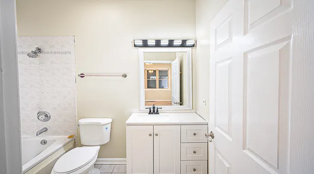 a bathroom with a toilet sink a mirror a vanity and shower