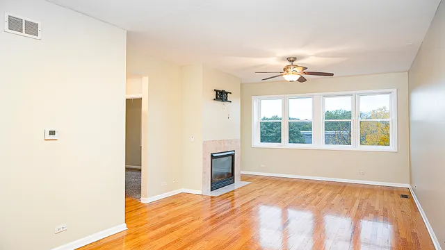 a view of an empty room with a fireplace and a window