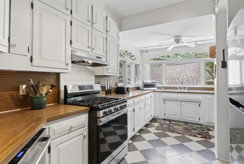 a kitchen with stainless steel appliances granite countertop a stove a sink and a white cabinets