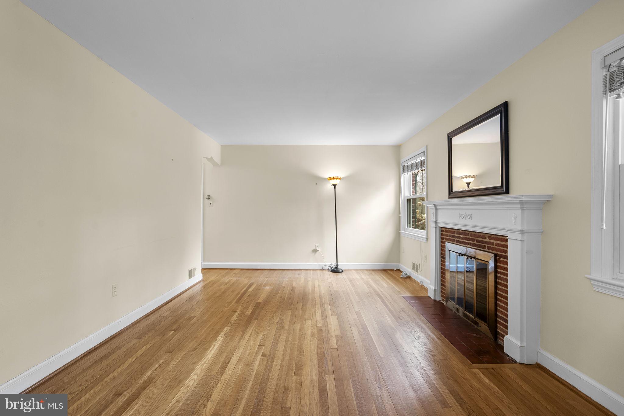 414 Hillmoor Drive Silver Spring, MD 20901 - Photo 11 of 49 an empty room with wooden floor fireplace and windows