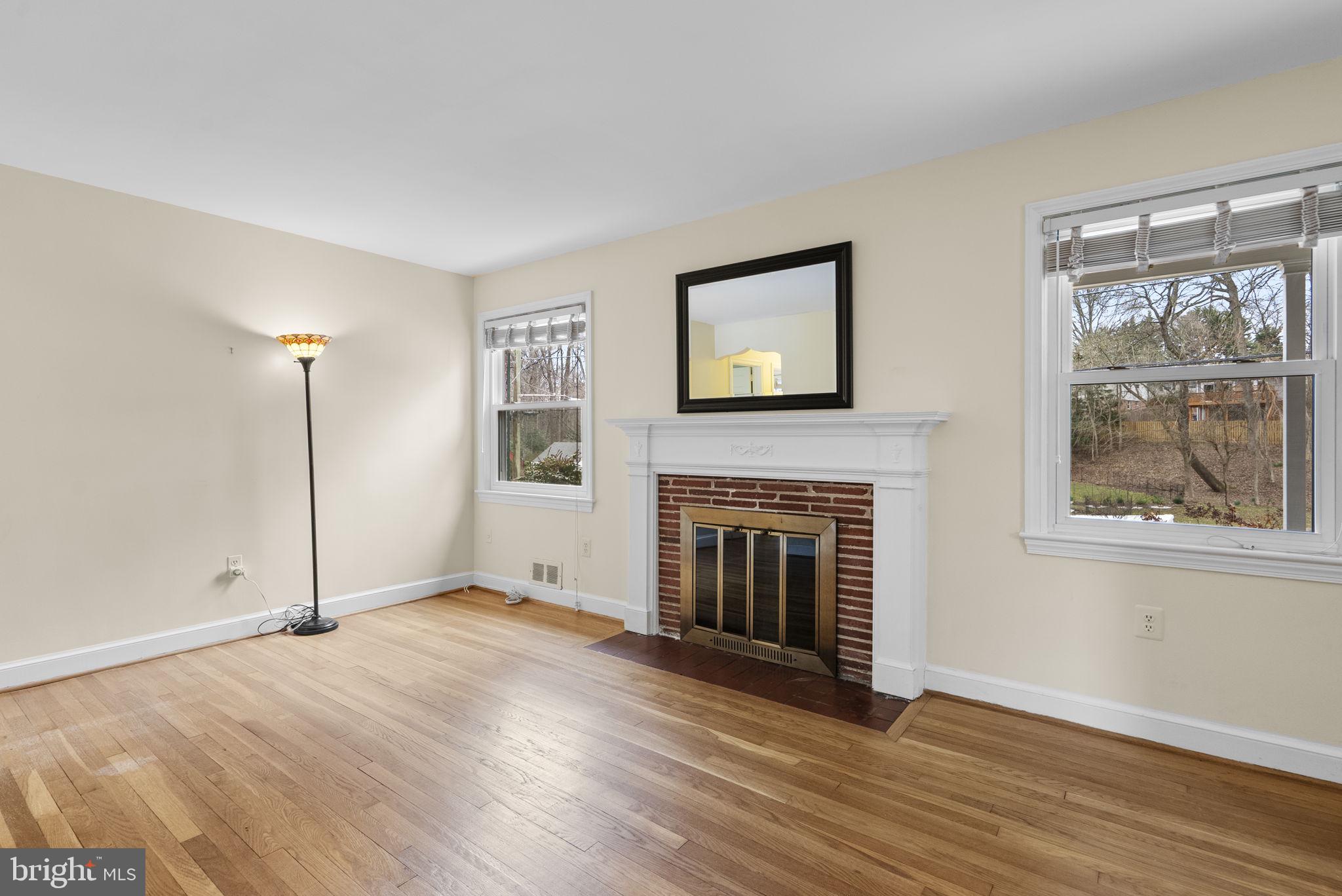 414 Hillmoor Drive Silver Spring, MD 20901 - Photo 12 of 49 an empty room with windows fireplace and wooden floor