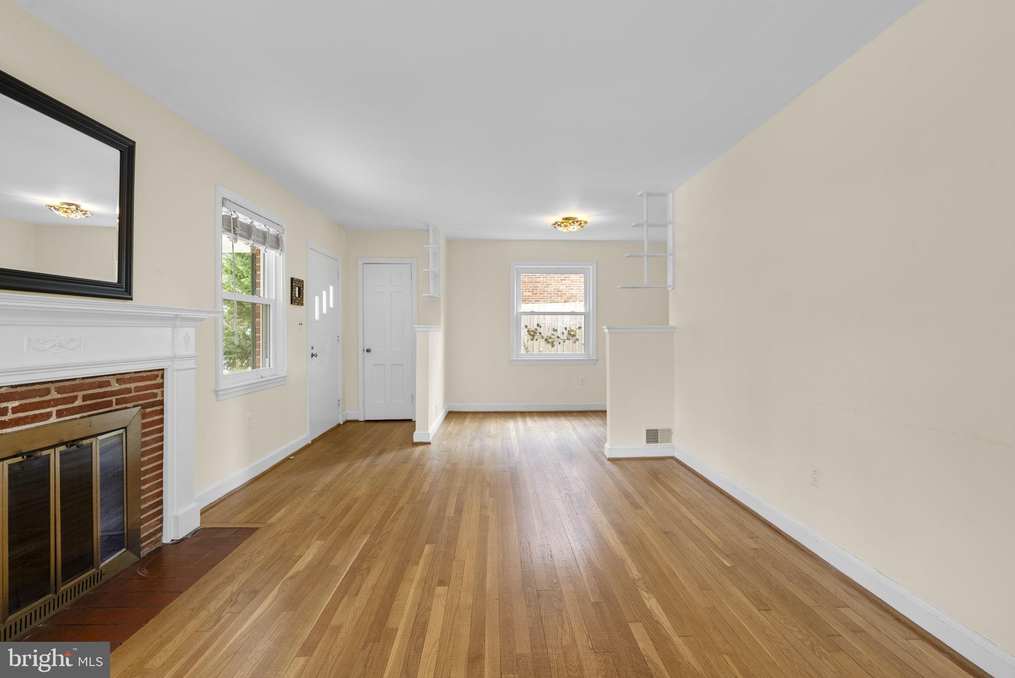 414 Hillmoor Drive Silver Spring, MD 20901 - Photo 14 of 49 an empty room with wooden floor fireplace and windows