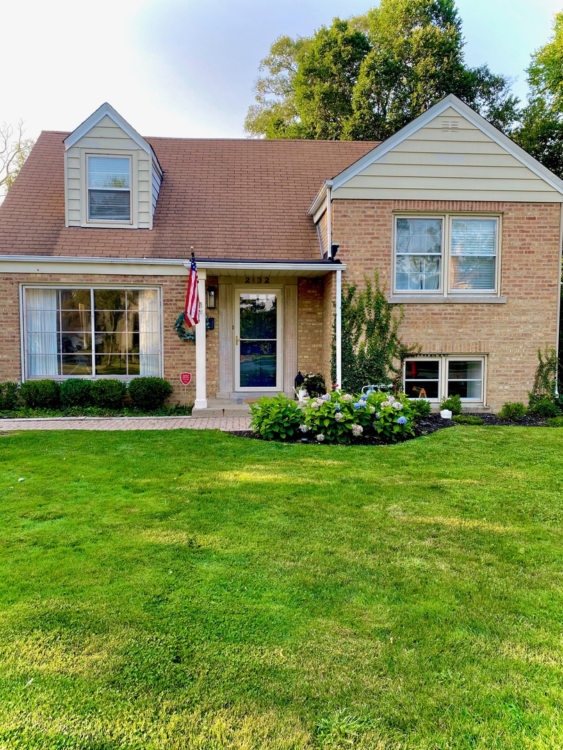 2132 Illinois Road Northbrook, IL 60062 - Photo 3 of 26 a front view of a house with a garden and yard
