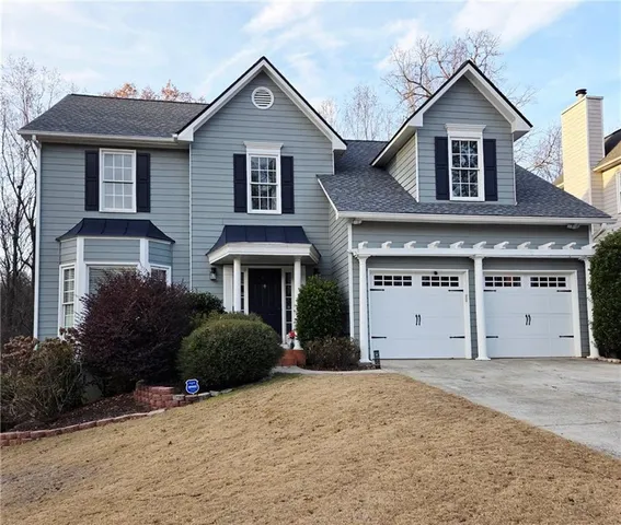 a front view of a house with a yard and garage