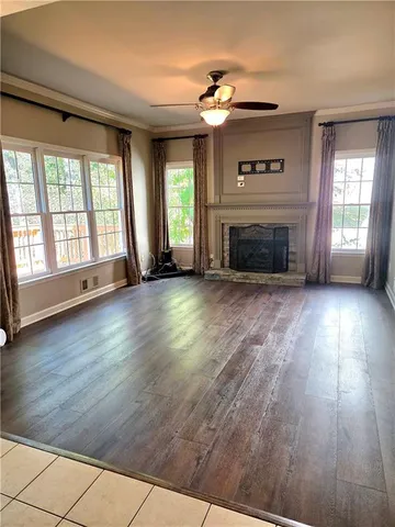 en empty room with windows and ceiling fan