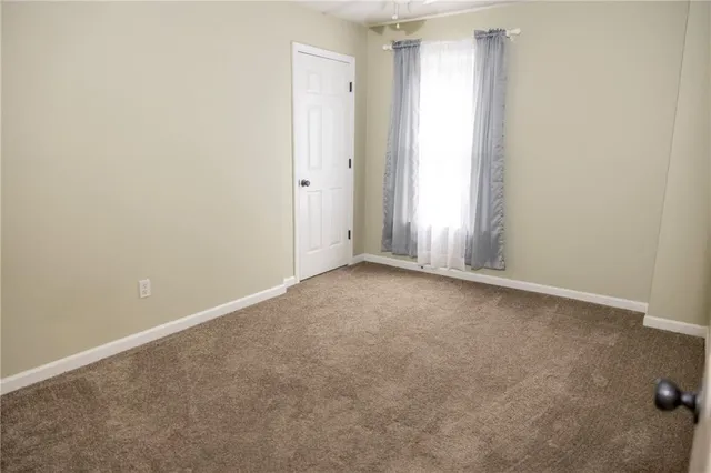 a bedroom with a bed and a large window with outer view