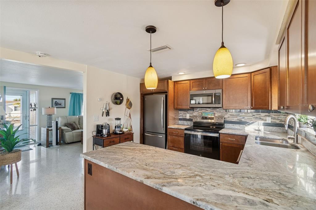 4940 Picture Avenue Holiday, FL 34690 - Photo 11 of 37 a kitchen with stainless steel appliances granite countertop a stove oven and a kitchen island