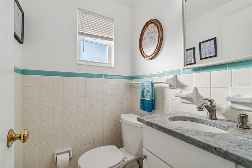4940 Picture Avenue Holiday, FL 34690 - Photo 21 of 37 a bathroom with a granite countertop toilet a sink and a mirror