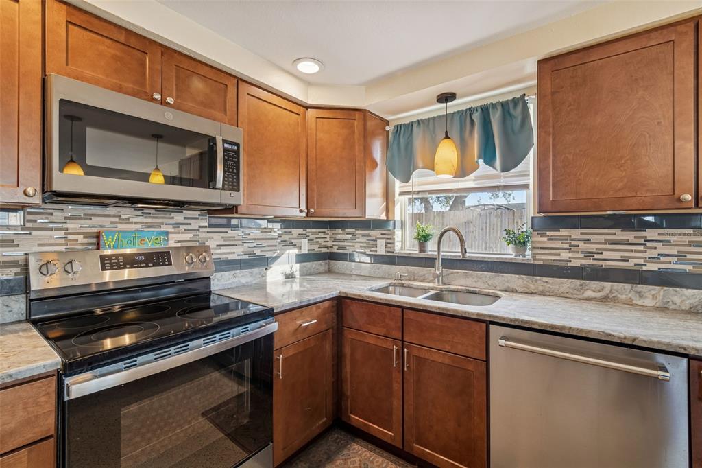 4940 Picture Avenue Holiday, FL 34690 - Photo 8 of 37 a kitchen with a sink stove and microwave