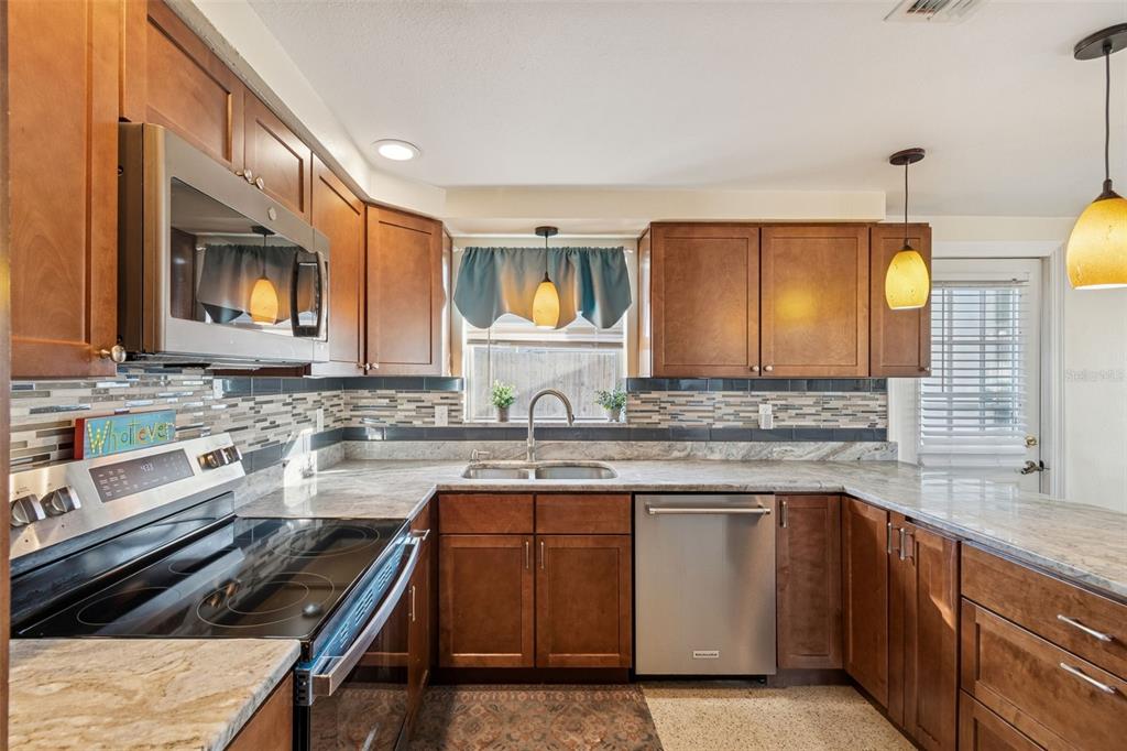 4940 Picture Avenue Holiday, FL 34690 - Photo 10 of 37 a kitchen with a sink and wooden cabinets
