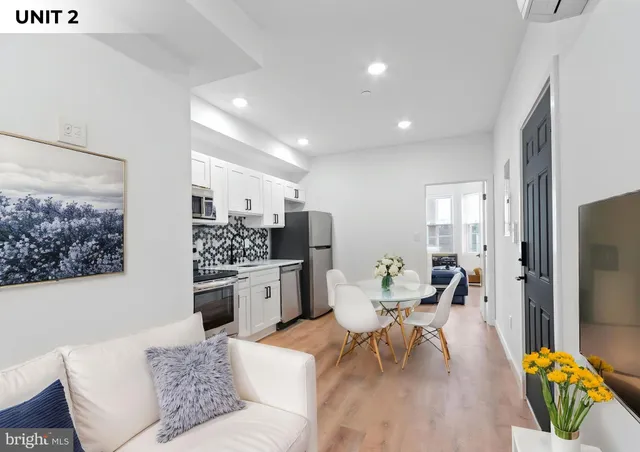 a living room with kitchen island furniture and a flat screen tv