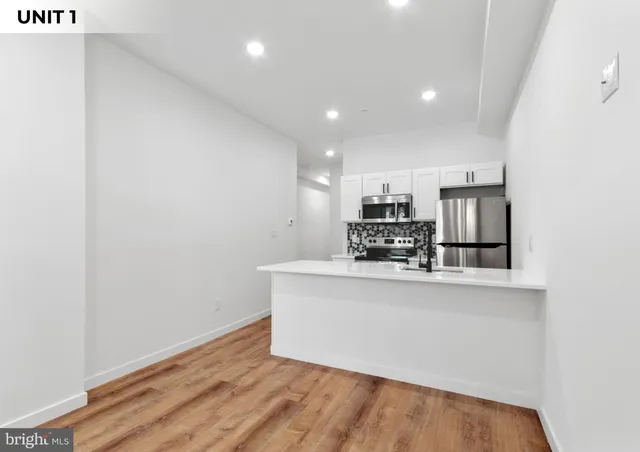 a view of kitchen with stainless steel appliances granite countertop cabinets and wooden floor