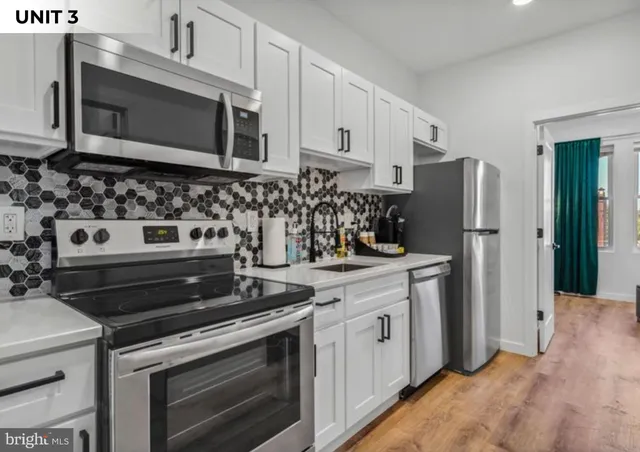 a kitchen with stainless steel appliances a stove a microwave and cabinets