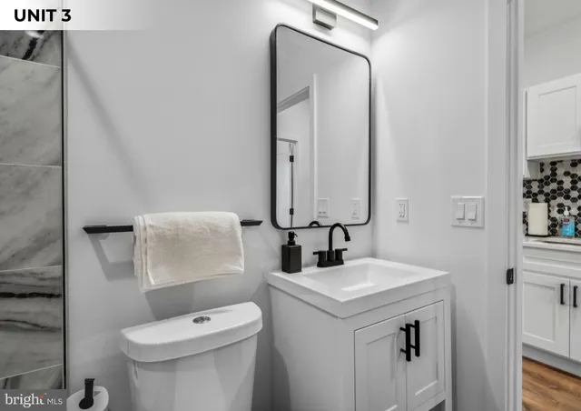 a bathroom with a toilet sink and mirror