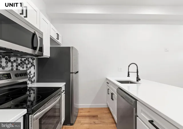 a kitchen with stainless steel appliances a sink stove and cabinets