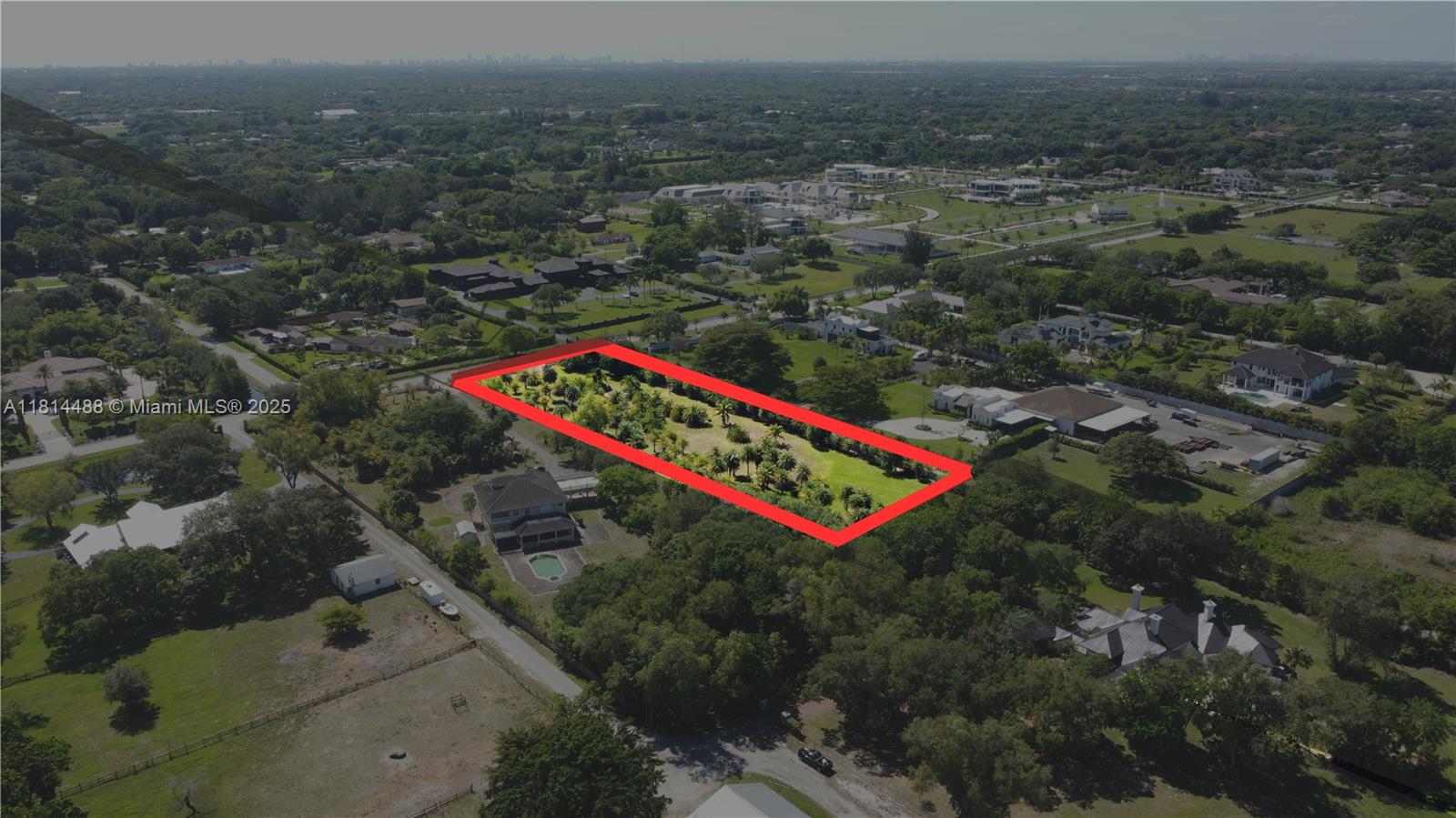 an aerial view of residential houses with outdoor space and trees