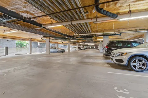 a view of parking garage with cars parked