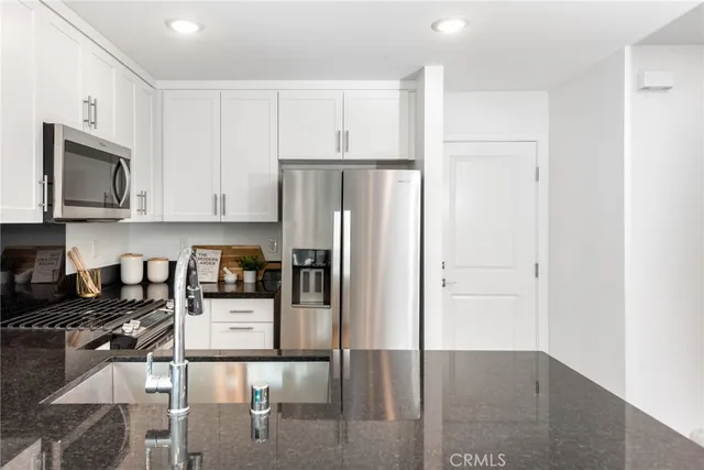a kitchen with stainless steel appliances granite countertop a refrigerator and cabinets