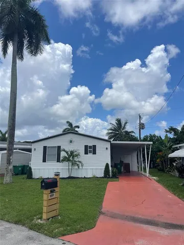 a front view of a house with a garden and yard