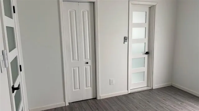 an empty room with wooden floor and closet