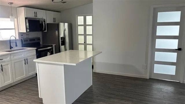 a kitchen with stainless steel appliances a refrigerator stove and microwave