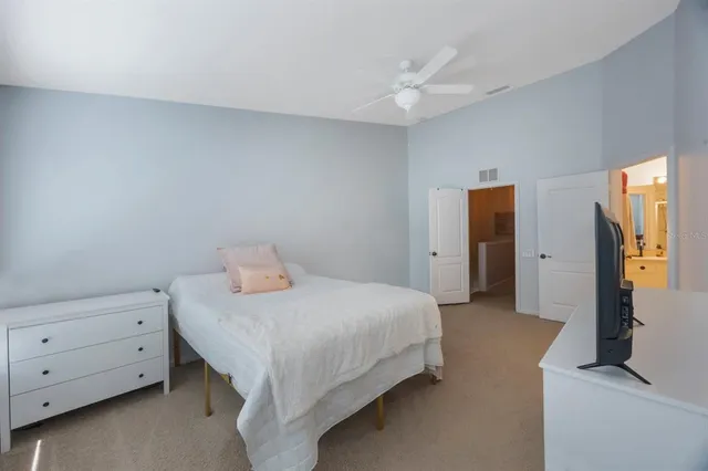 a bedroom with a bed and a flat tv screen on wall
